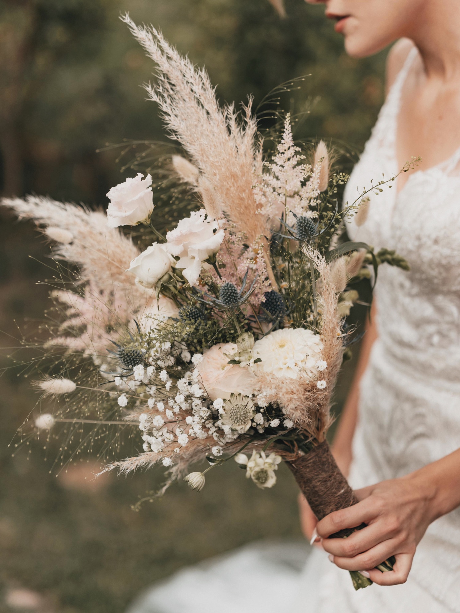 Céline tenant son bouquet de mariée aux tons ivoire avec pampas, avant sa mise sous cadre