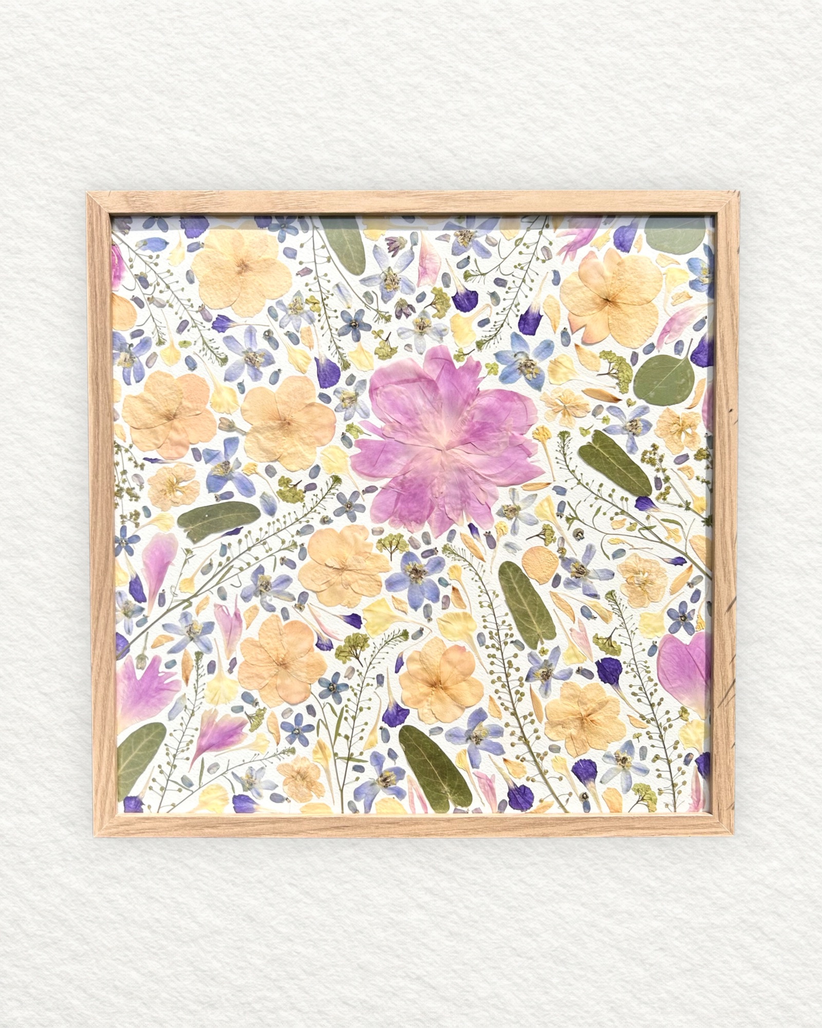 Composition carrée de fleurs pressées blanches, mauve et bleu, cadre bois naturel, format moyen